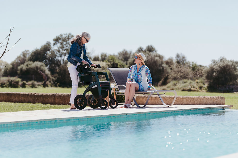 Two women with a mobility device enjoying poolside at a short-term vacation rental.