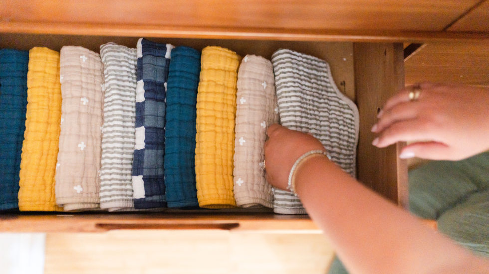 Woman arranging folded clothes in a drawer.