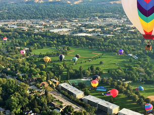 An arial view of Boise, Idaho from a hot air balloon with other hot air balloons in view.