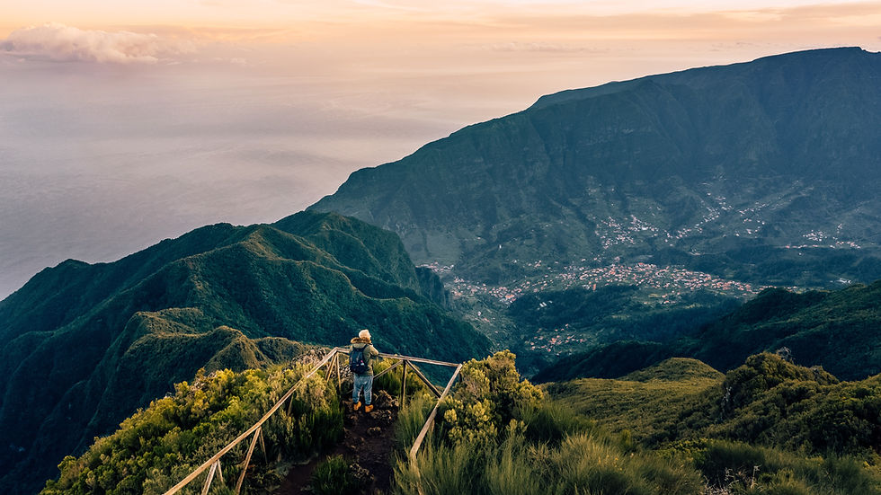 A person standing on top of a mountain in Madeira describing the sub section The Most Popular Regions in Portugal for the blog post Unlocking the Potential: 10 Compelling Reasons to Live in Portugal offered by the trusted German real estate buyer’s agent Benjamin Seide CEO of Lagos Homes in the Algarve