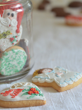 Selection of iced Christmas biscuits displayed in and around a jar