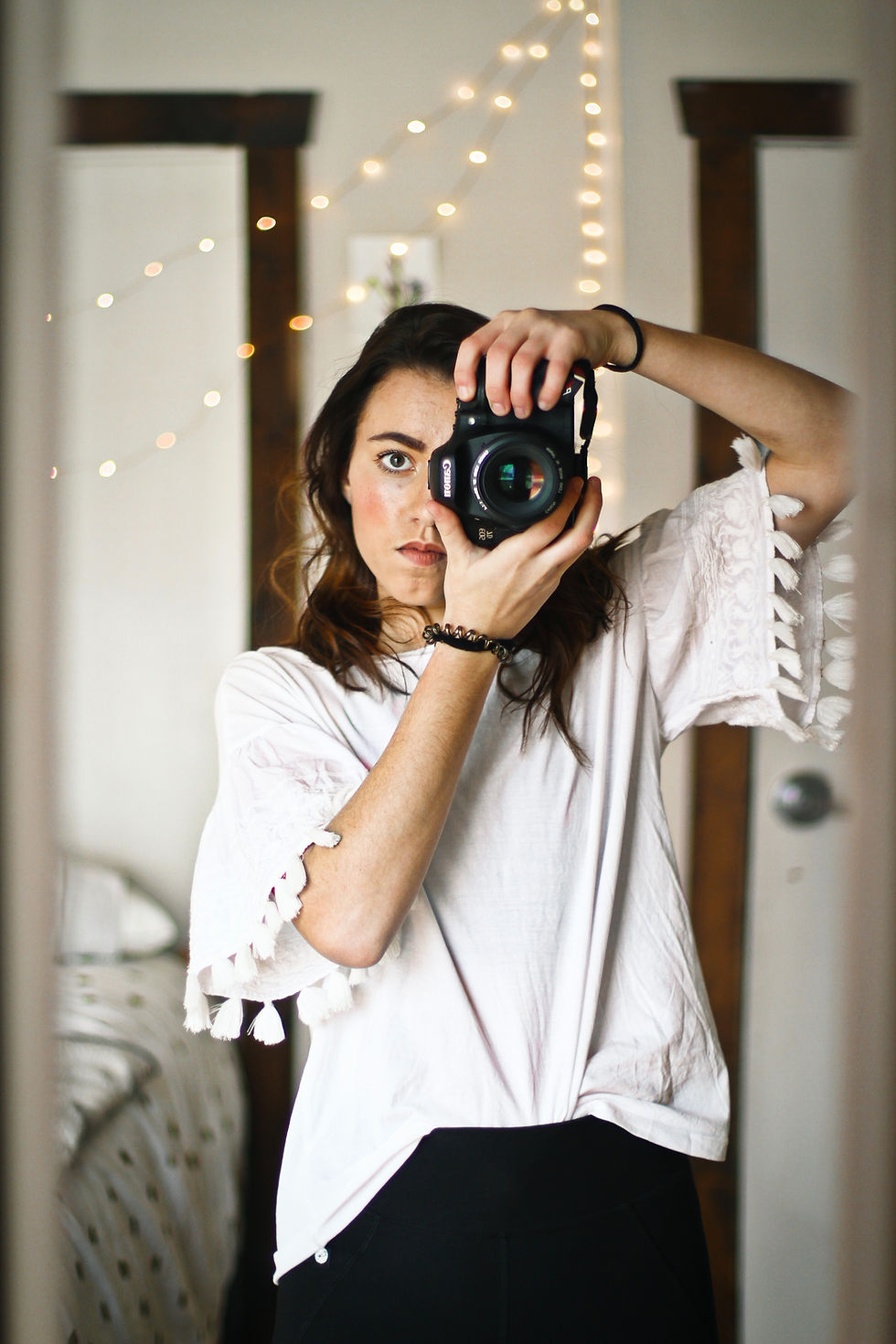 Fotoğrafçı, ayna karşısında profesyonel fotoğraf makinesi ile fotoğraf çekiyor.