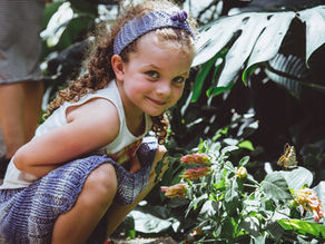 Young child tending flowers in a garden, symbolizing making room for new growth through hands-on connection with nature.