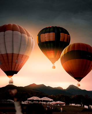 Three hot air balloons by sunset