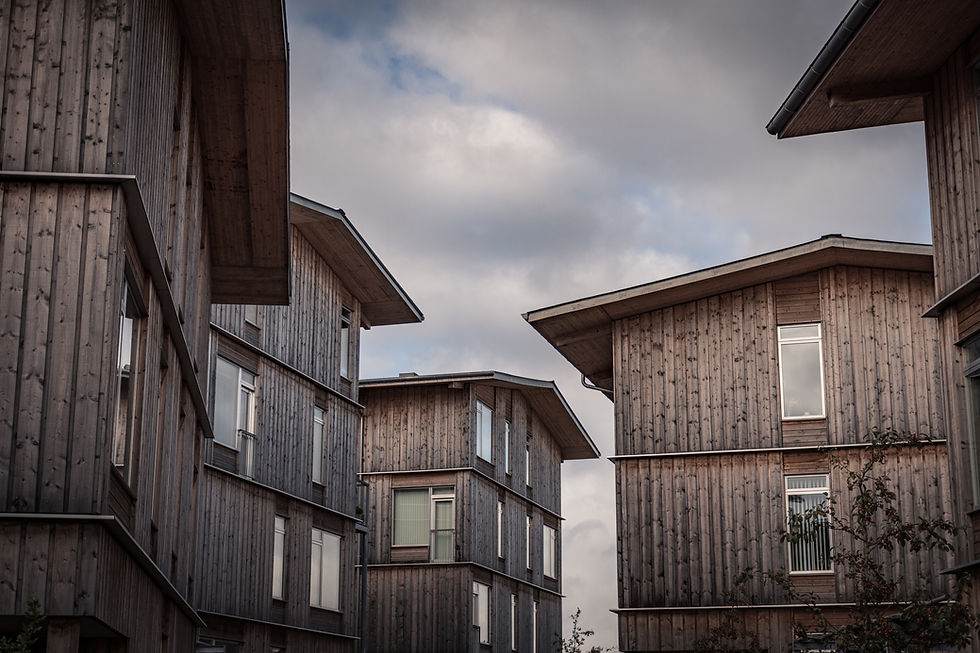 Hus i grått ubehandlet treverk mot grå himmel