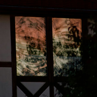 Una immagine sfocata dietro superficie traslucida, evoca la condizione diasporica