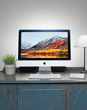 An iMac sitting on a table with its photos organized.