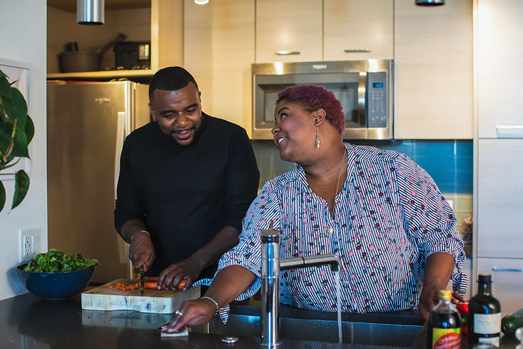 Couple cooking together in the kitchen, preparing a meal.