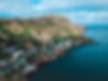 An arial shot of a small harbour-side community with colourful houses of all shapes and sizes.