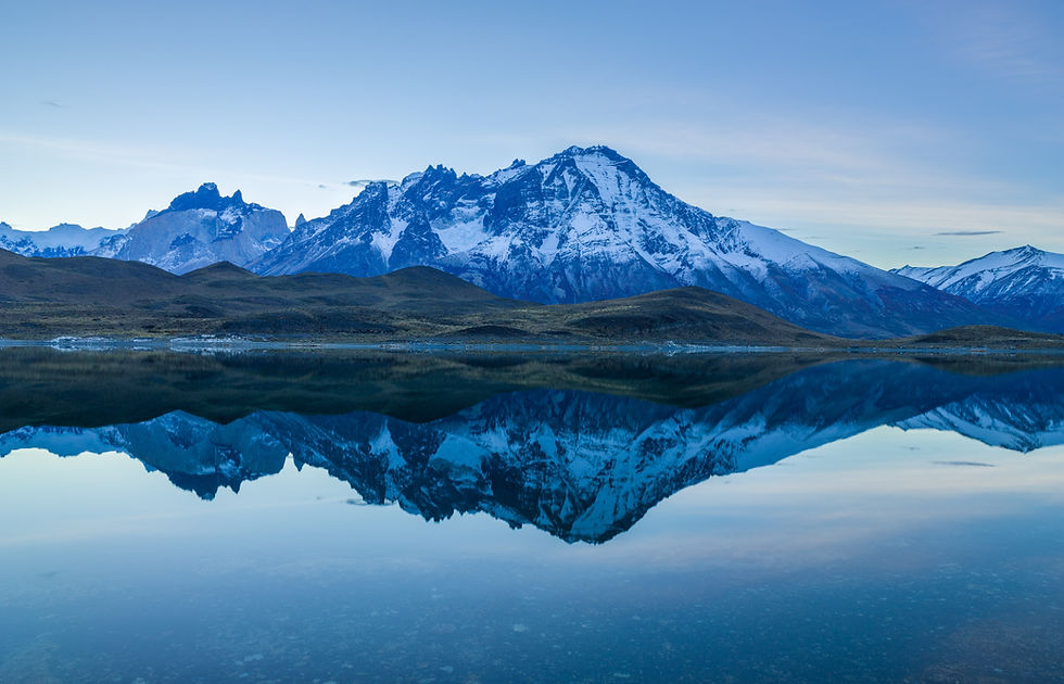 Torres del Paine National Park in Patagonia, Chile, with rugged mountains, shimmering blue lakes, and dramatic cloud formations