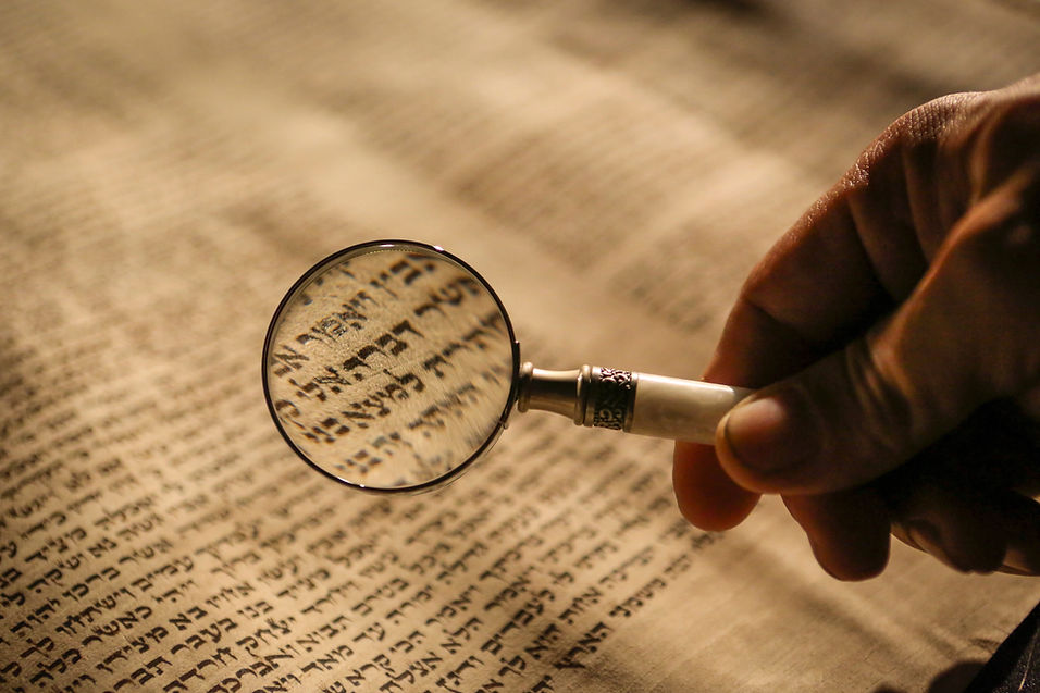 Magnified glass looking at wise words on a scroll