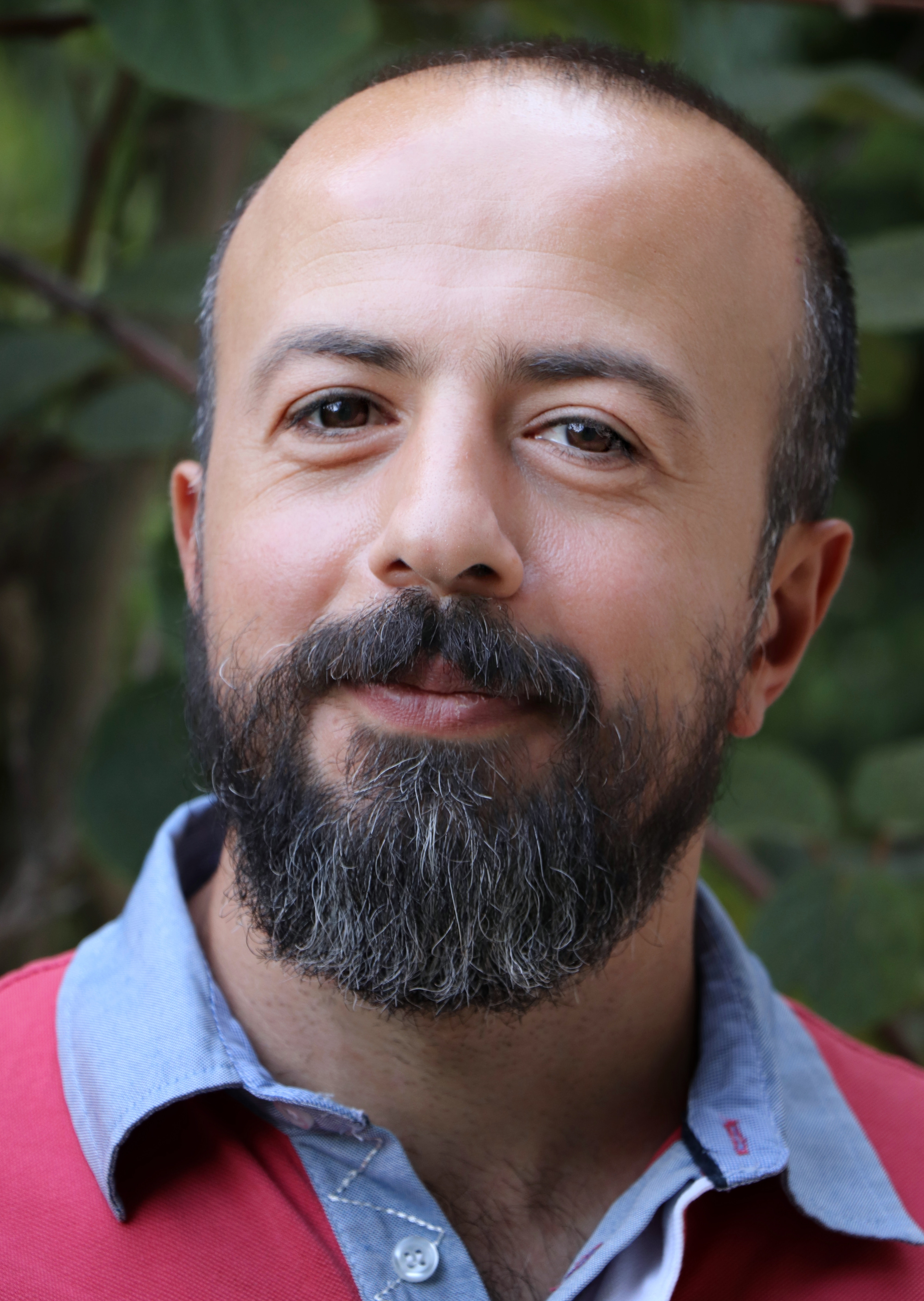 Smiling man with a beard and mustache outdoors