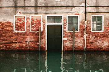 A flooded brick home requires water damage restoration
