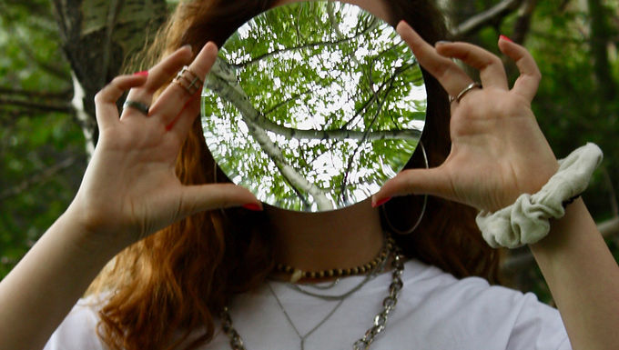 ragazza con specchio e alberi
