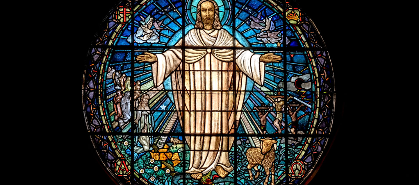 Stained glass of Jesus with open arms, symbolising divine forgiveness and unconditional love