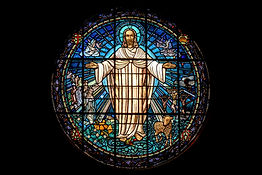 Stained glass of Jesus with open arms, symbolising divine forgiveness and unconditional love