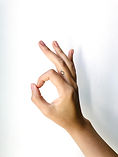 A hand makes an "OK" sign against a white background.
