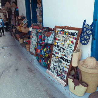 Display of handmade woven bags and accessories at an outdoor Israeli market.