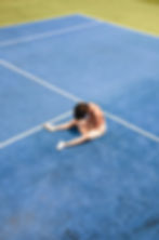 Tenista agotada sentada en la pista