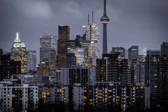 Toronto skyline at dusk with the CN Tower and many lit buildings.