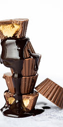 Un visiteur admirant les étapes de fabrication du chocolat dans une chocolaterie artisanale du Jura.