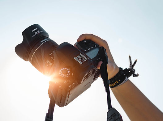 Image of a photographer holding a camera towards the sky
