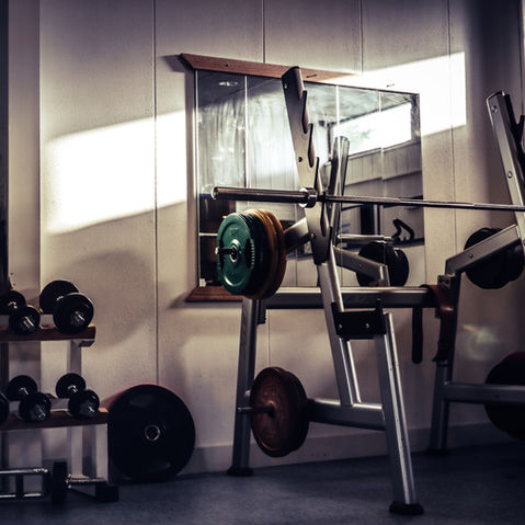 An empty gym, featuring a squat rack.