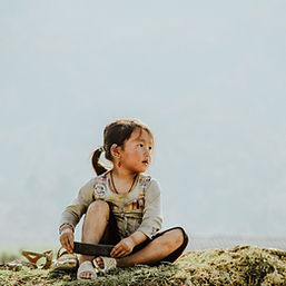 A little girl gazing solemnly into the distance. 