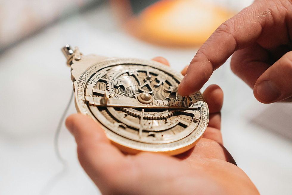 Une main réglant un astrolabe