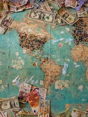 A map of the world with bank notes of many currencies scattered around the edges. Symbolic of the inter-connectedness of the global economy shaken up by the 2008 Recession. Image by Christine Roy