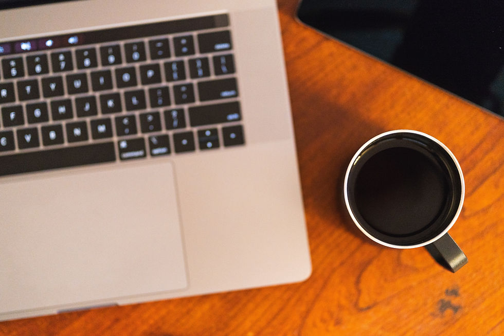 A laptop and a coffee on a desk