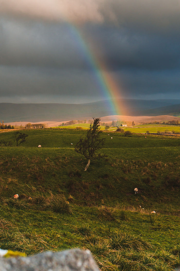 Rainbow over a small house on a farm
