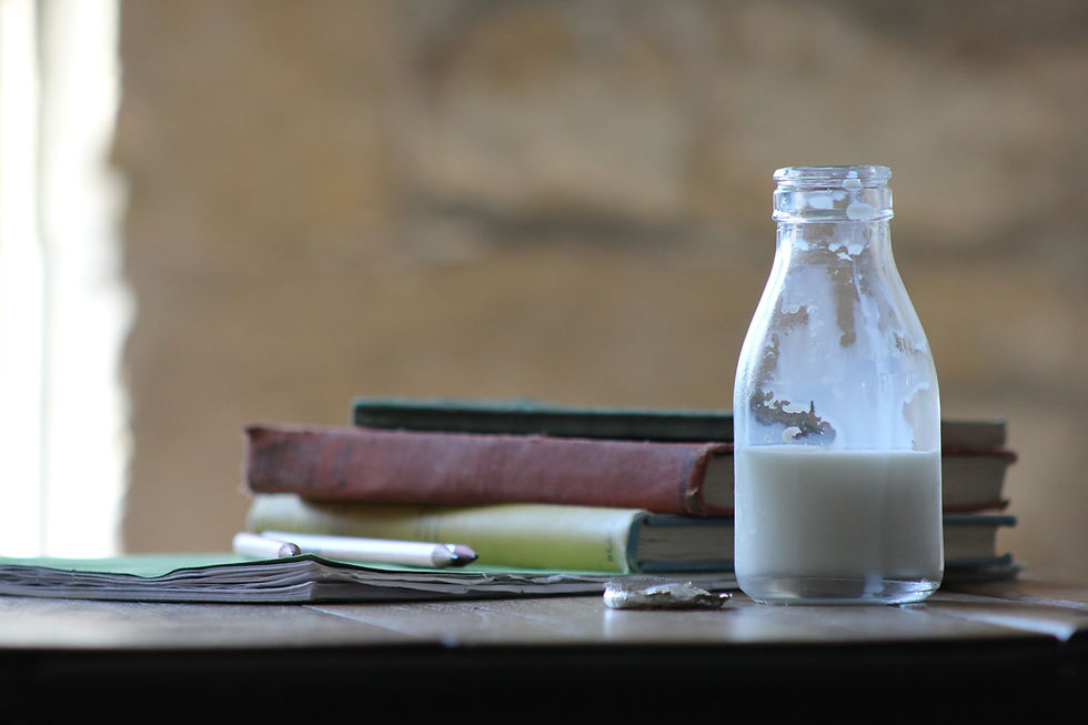 half empty glass bottle of milk on table