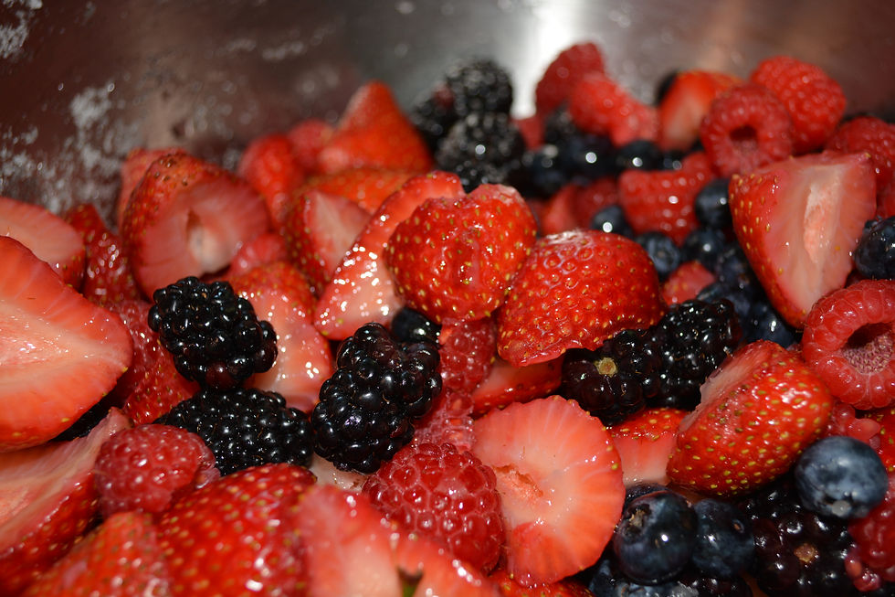 Mixed berries, including strawberries, blackberries, raspberries, and blueberries, are in a metal bowl, showcasing a fresh, vibrant look. Berries reduce inflammation
