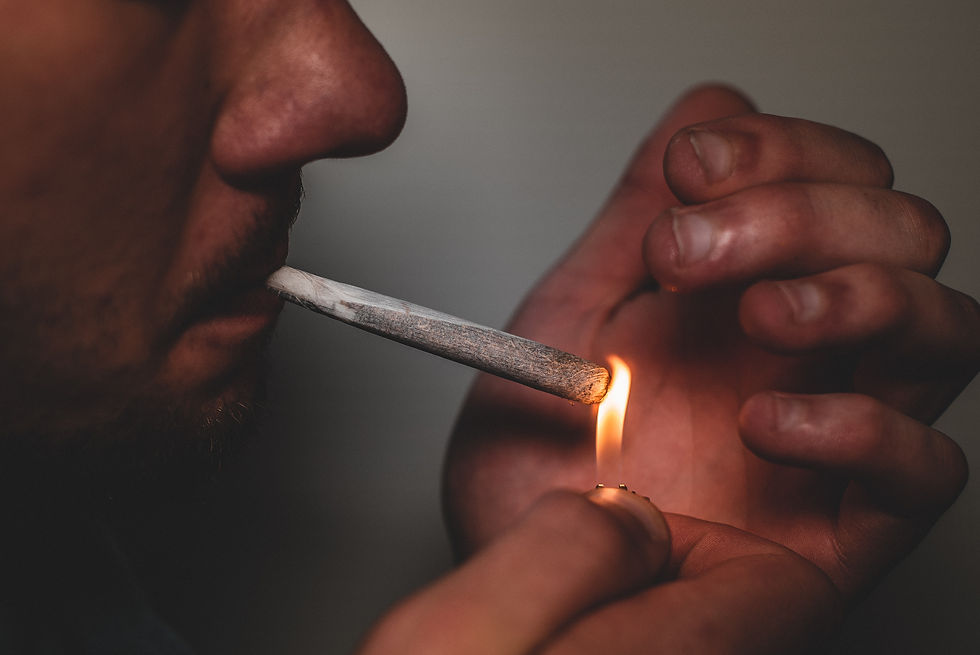 Un gros plan d'un homme allumant un joint