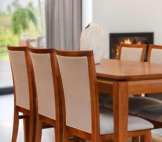 Wooden dining table with upholstered chairs in a bright, modern dining room