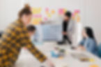 One man and 2 women with post it notes on the wall