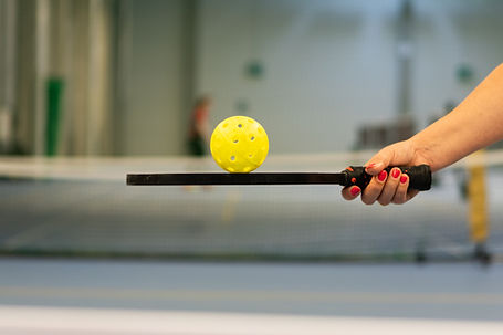 Close Up on Woman's Hand Balancing Pickleball on Pickleball Paddle