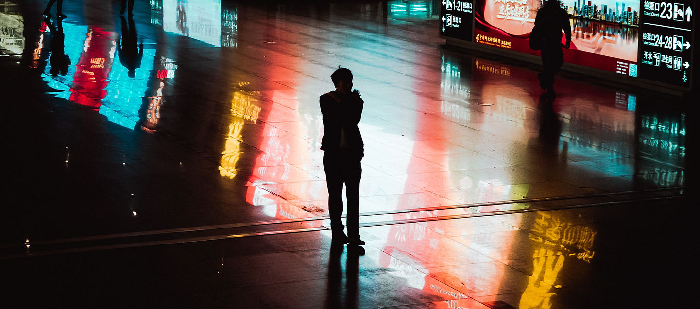 Man standing in neon-lit hallway – representing intentional content consumption and media mindfulness.