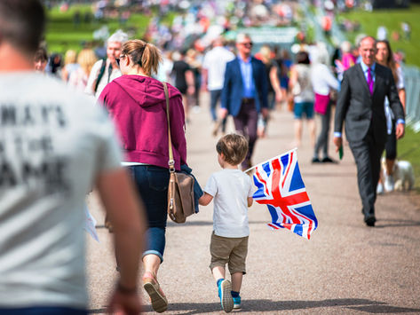 Mother and child walking together holding a Union Jack flag, representing families applying for 10-Year Long Residence ILR in the UK.