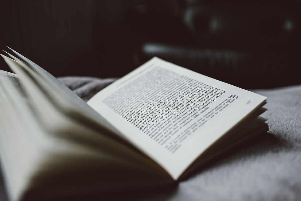 A open book on a bed in a bedroom.