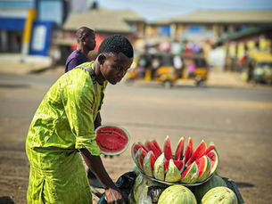 man selling watermelon on a wheelbarrow