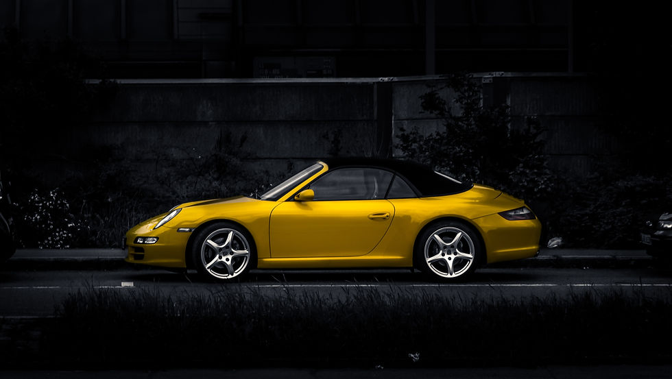 Voiture de sport jaune élégante garée sur une rue sombre.