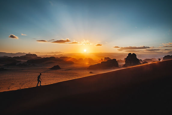 man hiking up a mountain during sunrise