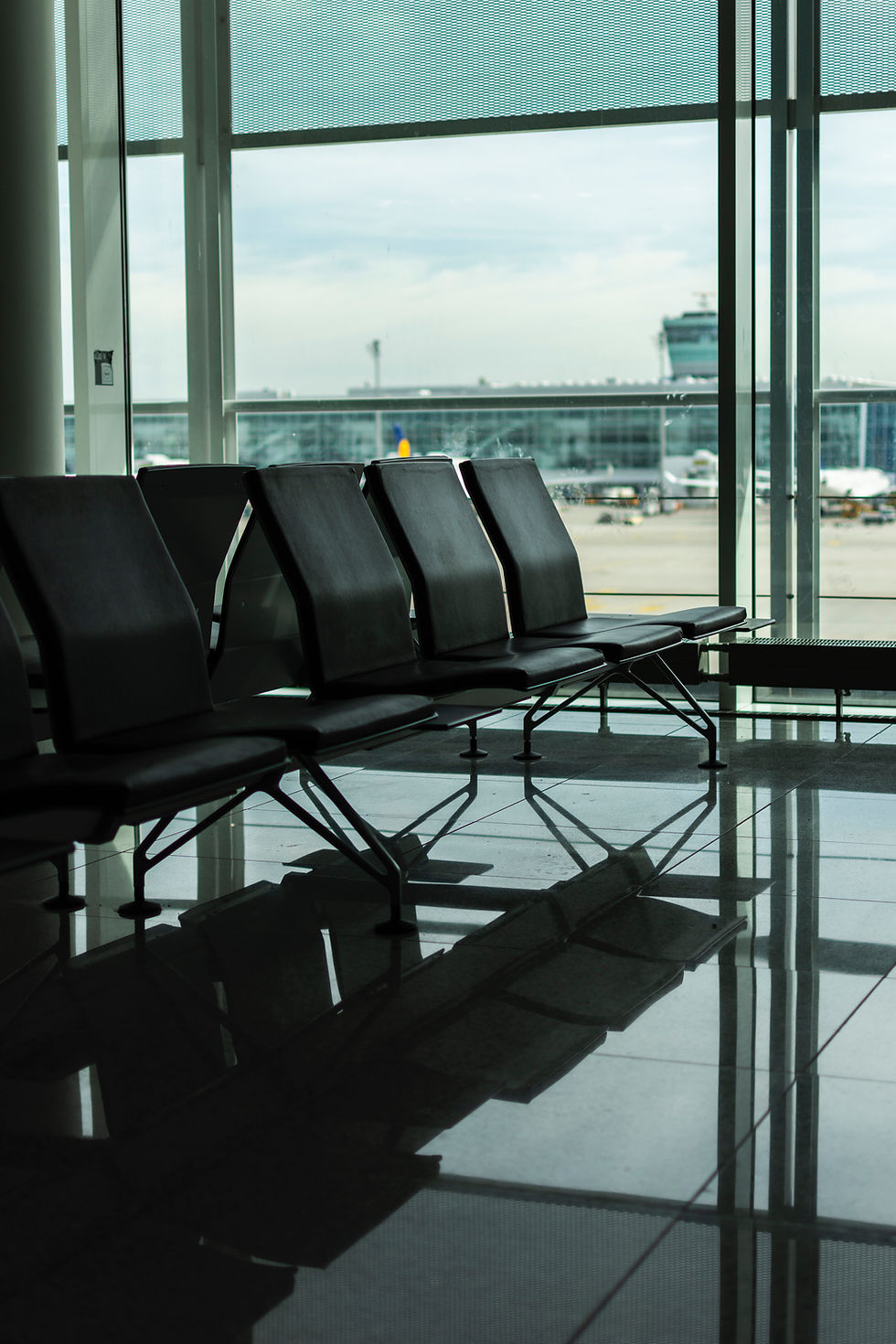 a row of empty seats at the airport echoes the stoic feeling of a long layover