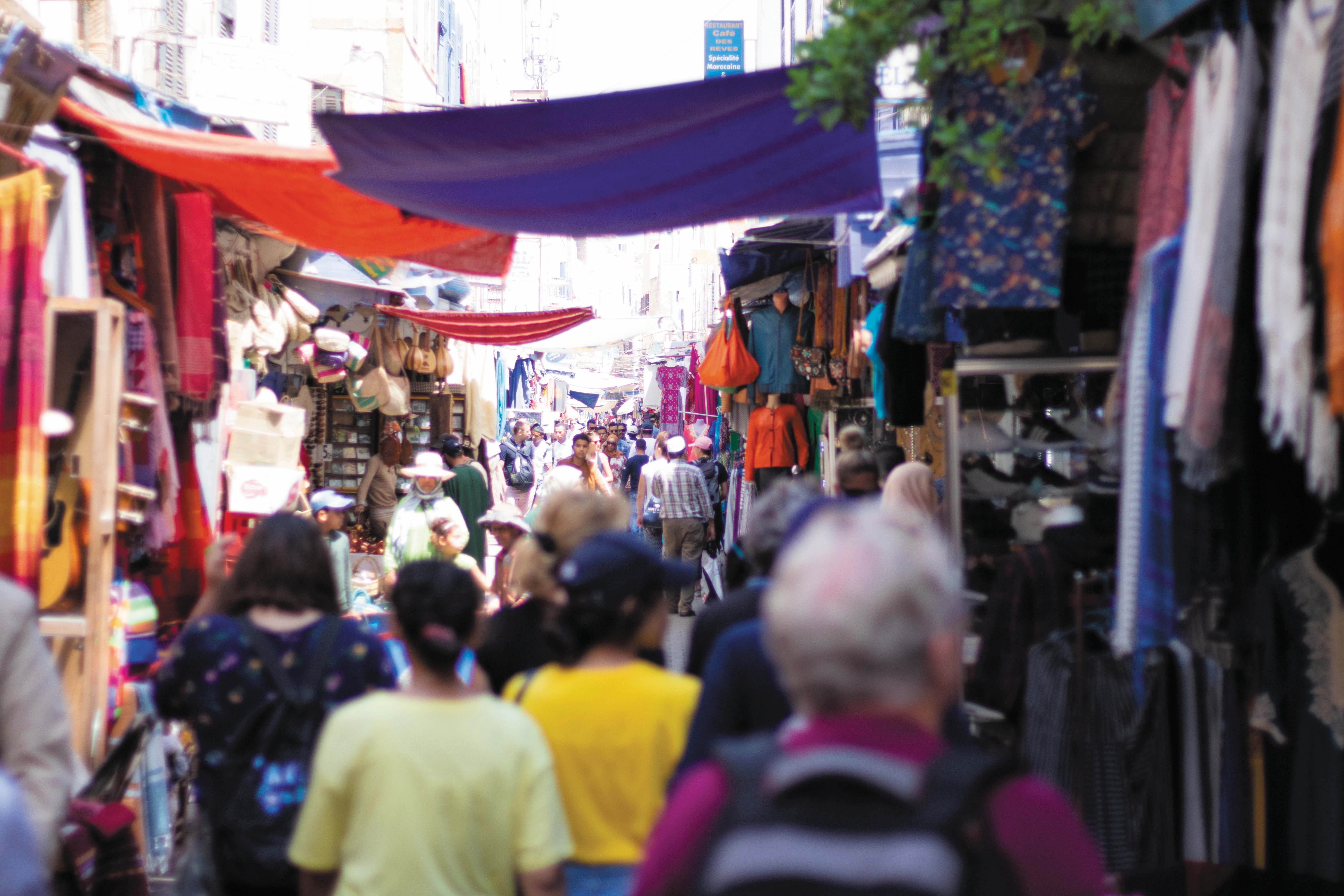 Eye-level view of a busy Moroccan market street with colorful stalls