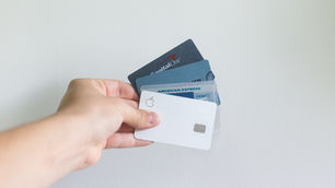 Hand holding several credit cards, illustrating government spending and fiscal policy in Vermont.