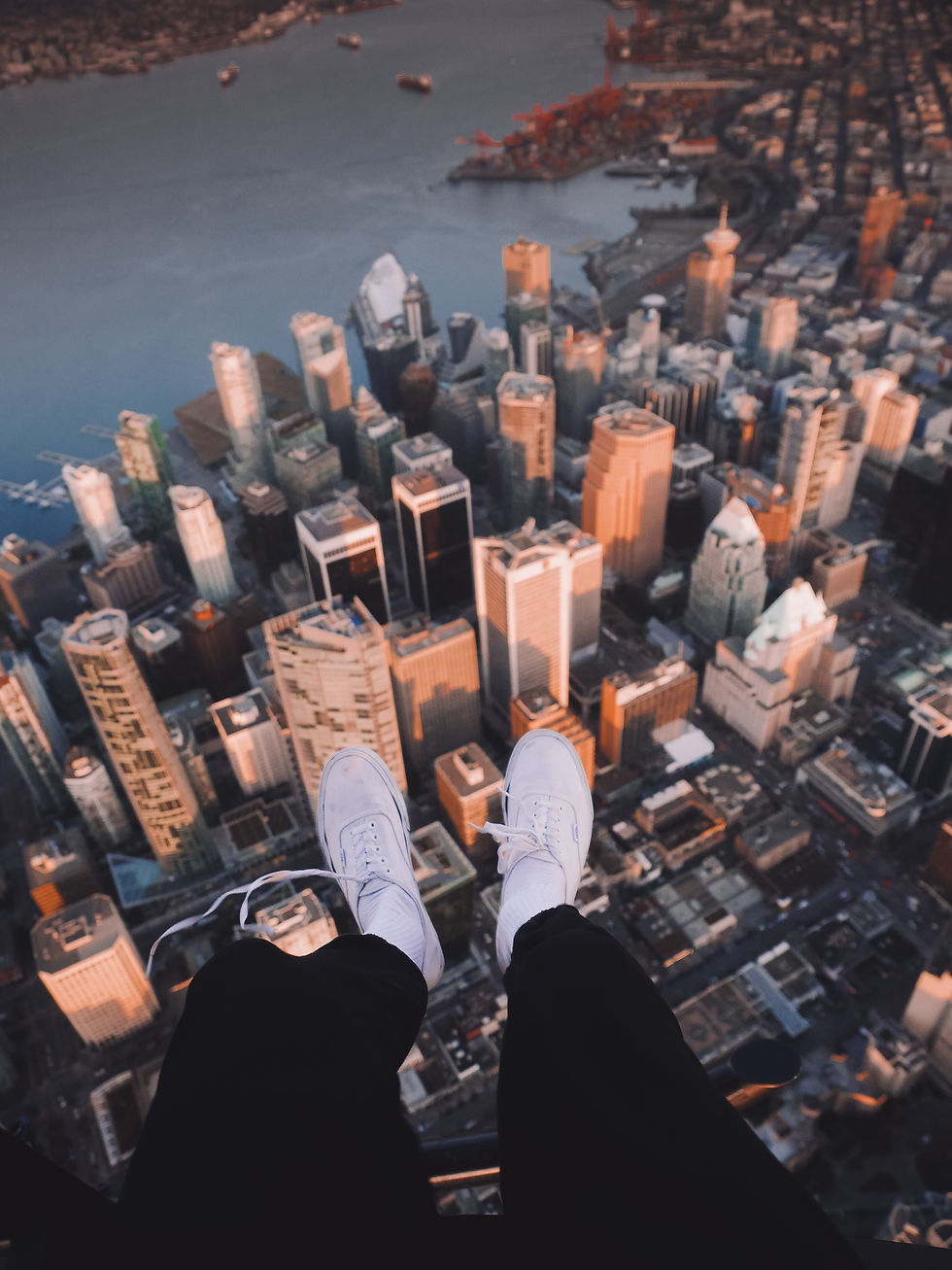A pair of feet dangling off a tall building