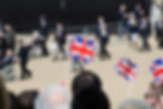 parade of people with three union jack flags waved