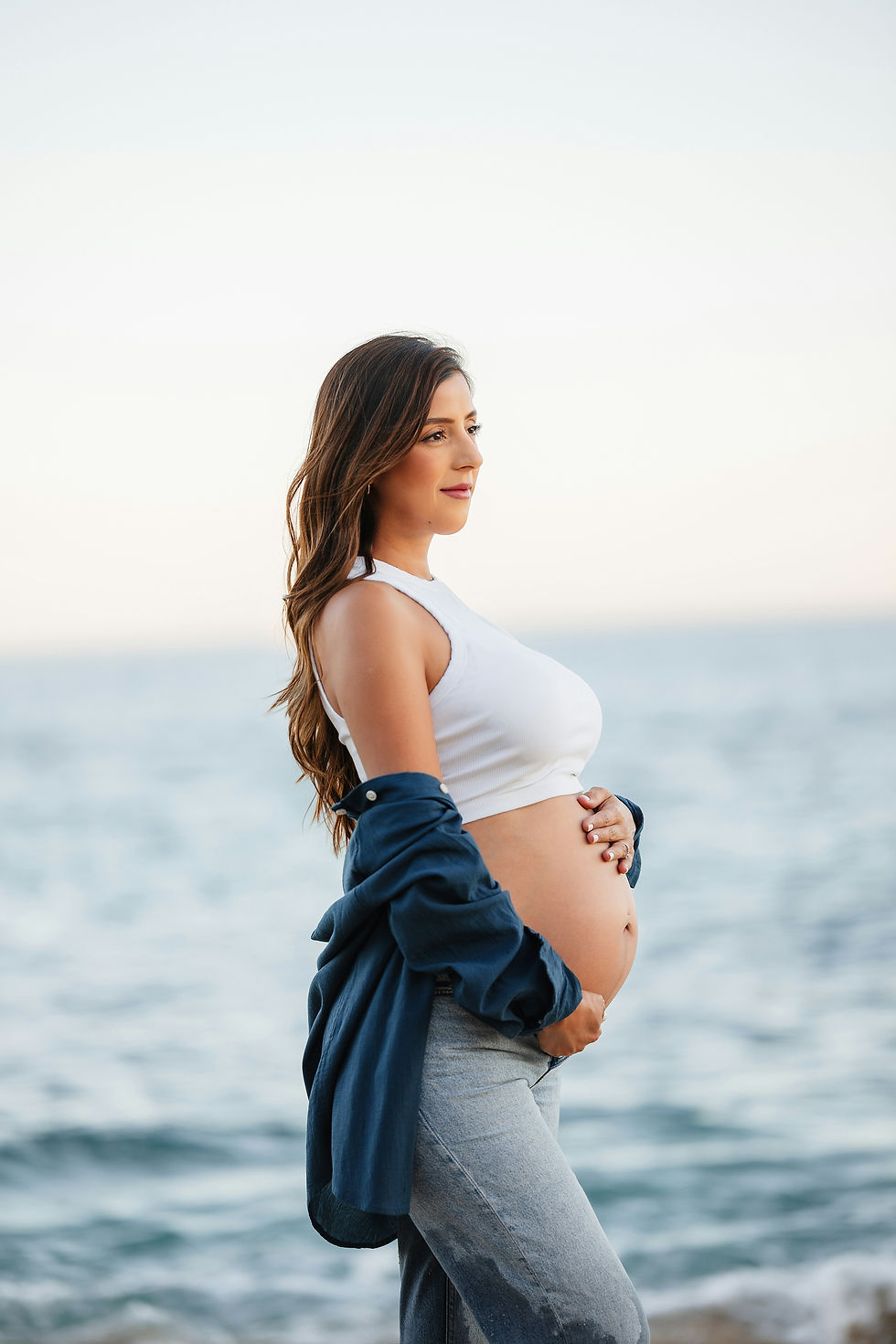 pregnant woman standing by the ocean